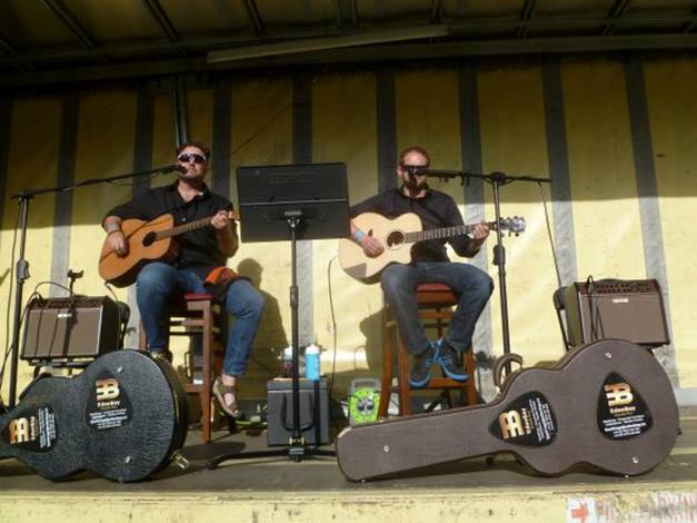 A group of men playing guitars on a stage

Description automatically generated with medium confidence