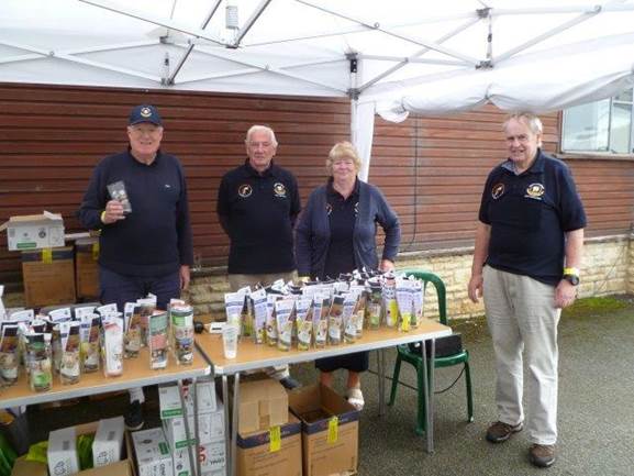 A group of people standing next to a table with bottles of liquid

Description automatically generated with low confidence