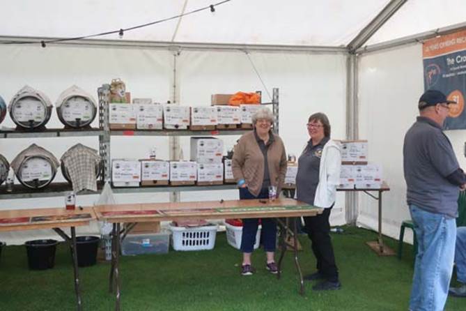 A couple of women standing in a tent

Description automatically generated