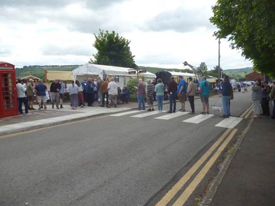 A group of people standing on the side of a road

Description automatically generated with medium confidence