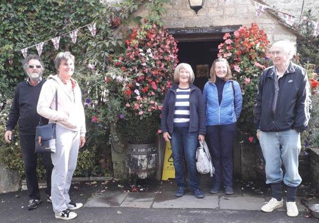 A group of people standing in front of a building with flowers

Description automatically generated with low confidence