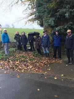 A group of people standing under an umbrella

Description automatically generated with medium confidence