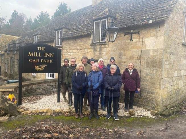 A group of people posing for a photo in front of a stone building

Description automatically generated