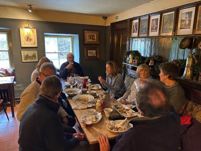 A group of people sitting around a table eating food

Description automatically generated with medium confidence