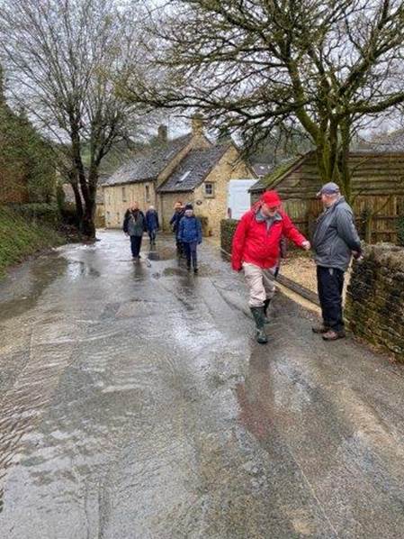 A group of people walking on a wet road

Description automatically generated with medium confidence